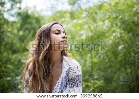 Beautiful young woman with closed eyes in the forest