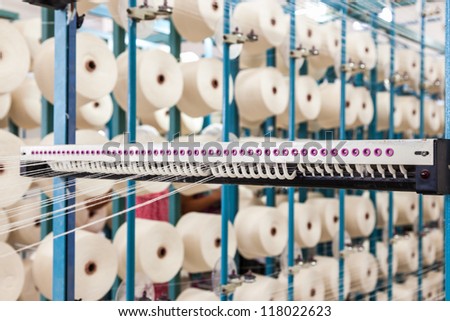 cotton threads coming from multiple small cotton cones and combined together in a yarn factory