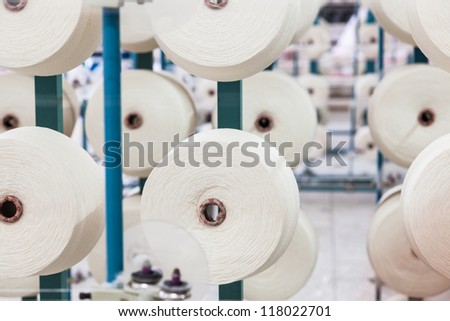 cotton cones stacked in a big rack in a yarn factory