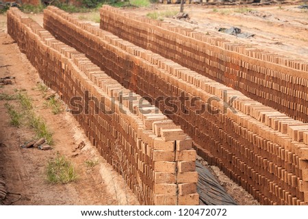 brick factory with multiple wet mud brick mold stacked in rows, waiting for wind dry