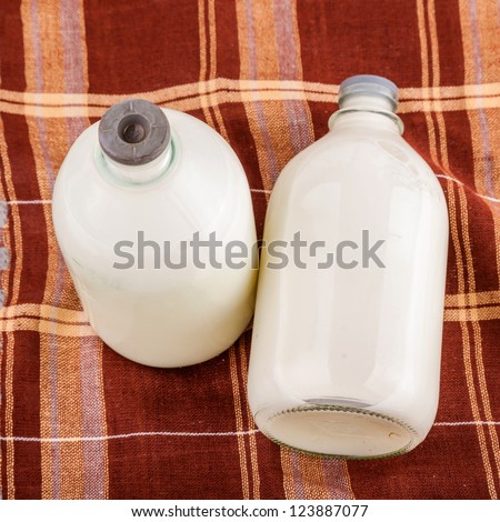 milk in glass bottle with brown cloth as background
