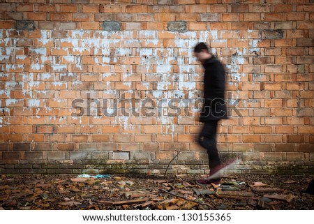 blurred black man walking through a old weathered wall