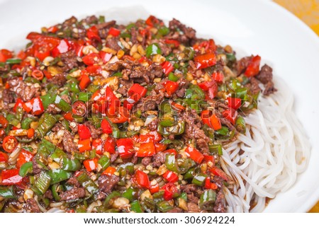 chinese rice noodle with red and green chili sauce stir fried with beef, a popular chinese dish