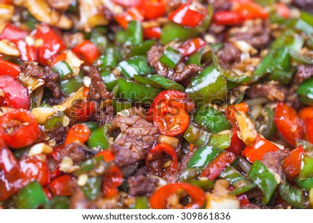 chinese rice noodle with red and green chili sauce stir fried with beef, a popular chinese dish