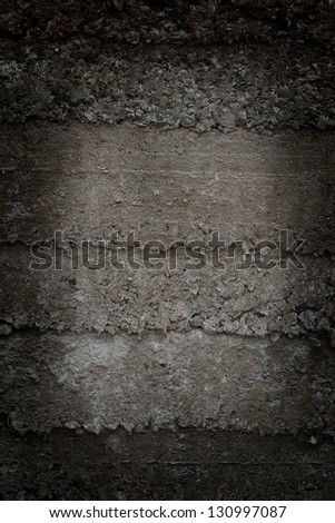 Texture of the old concrete wall with big bricks highlighted by dim light lamp