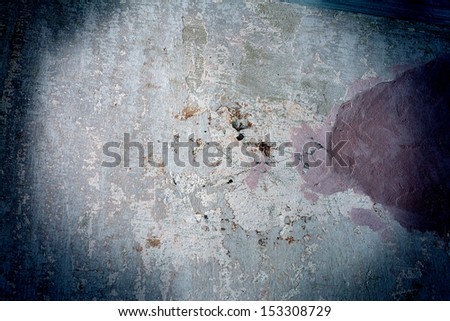 Texture of the old stained concrete wall with nail highlighted by dim light