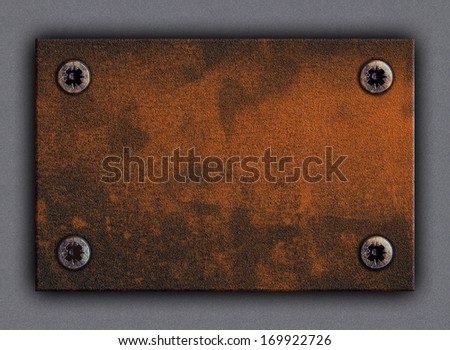 Old stain brown sheet iron plate framed and nailed by four screws to any building or wall background highlighted by sun, lamp or moon light