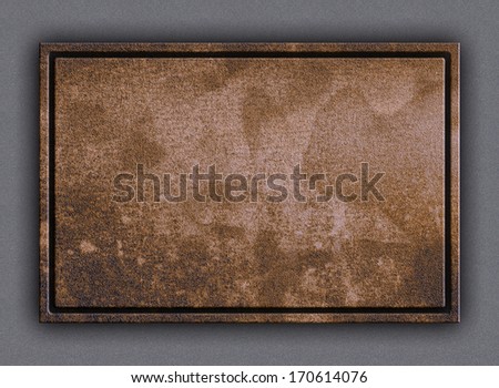 Old stain brown sheet iron plate framed and nailed  to any building or wall background highlighted by sun, lamp or moon light