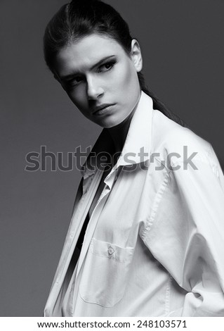 Portrait black and white of Female fashion model with serious face in white man shirt
