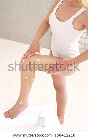 body-care - woman applying body lotion -