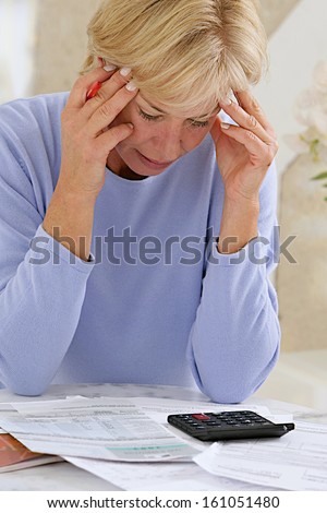 stressed senior woman is doing banking and administrative work at home