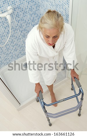 Elderly woman going out of the shower  with his walker.