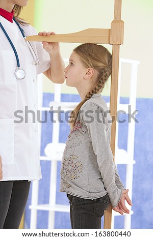 Doctor and little patient.  doctor checking little girl height