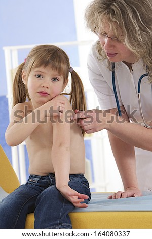 doctor and patient-Little fir showing to the doctor her painful shoulder