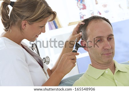 doctor examining ear of patient with an otoscope