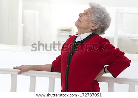 Old woman holding her lower back. Low back pain