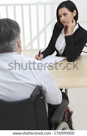 Businesswoman interviewing disabled job candidate in his office