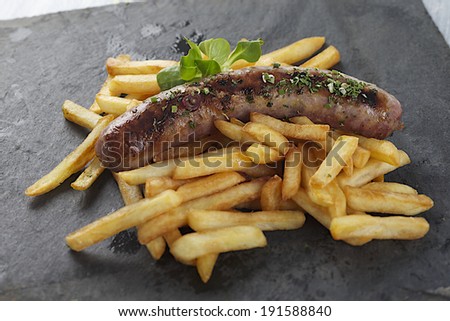 grilled sausage and french fries  on slate plate