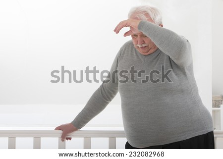 obese man looking worried with hand on forehead