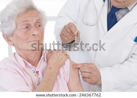 Doctor injecting vaccine to senior woman