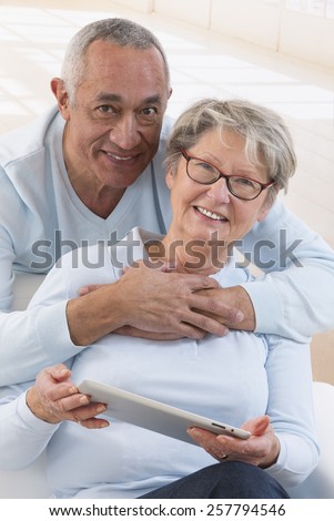 happy senior couple with tablet pc computer at home