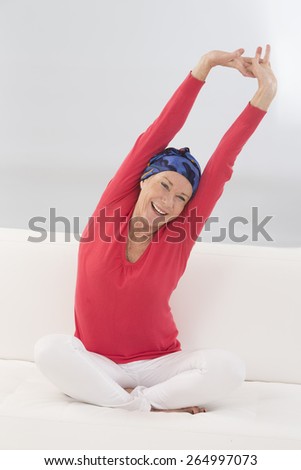 beautiful senior woman relaxing at home in her bed arm  up and stretching