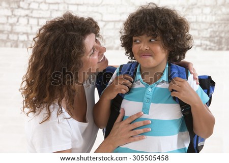 Mother having an conversation with her son before going to school and standing face to face