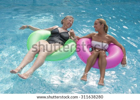 Grand mother and grand daughter having fun at swimming pool