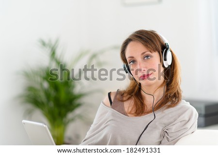 cheerful young women at home listening to music on her computer tablet