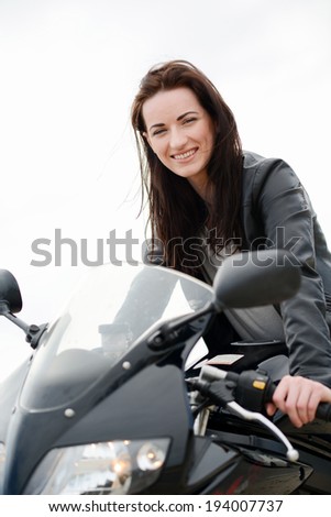 cheerful and beautiful young woman riding motorbike