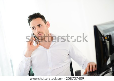 handsome young businessman at office with casual friday wear clothes having a telephone conversation