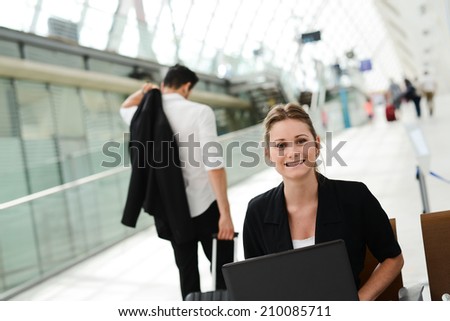 business woman sitting in public station and working with a computer in wifi area