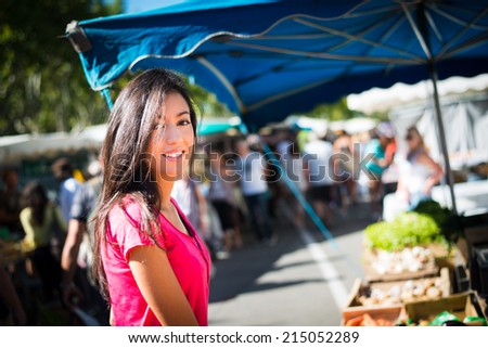 cheerful healthy young woman shopping in farmers market buying nice fresh organics fruits and vegetables