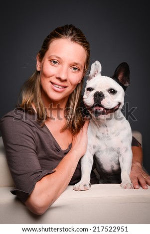 isolated studio shot of beautiful young woman with her pet little dog french bulldog