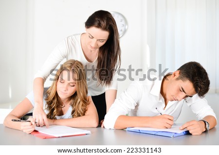beautiful young woman private teacher helping two students doing their homework