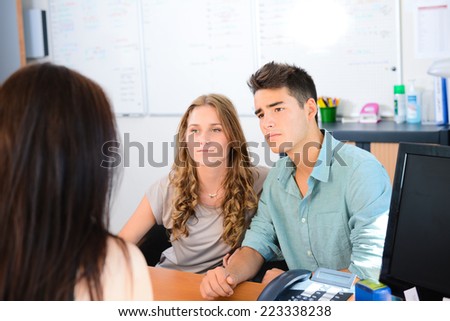 happy young couple getting advice in office with beautiful business woman