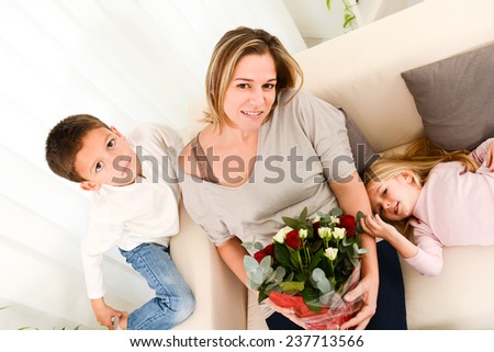 young happy children offering flowers to their mum during mother's day