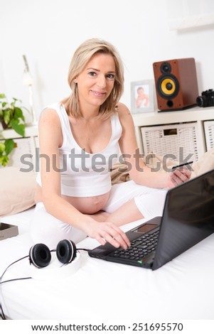 beautiful forty years old pregnant woman web surfing and shopping on internet