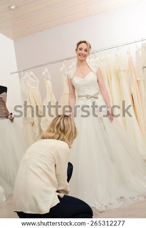 Beautiful young woman choosing a wedding dress in a bridal shop