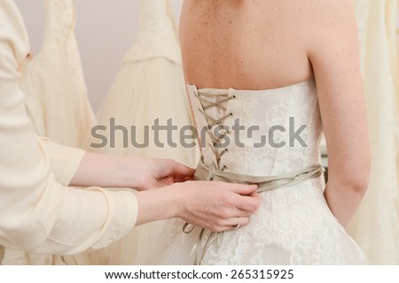 detail of hands adjusting wedding dress lace
