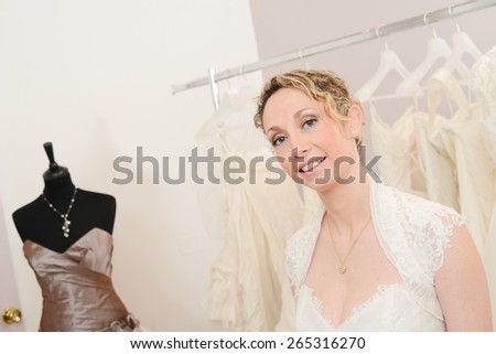 Beautiful young woman choosing a wedding dress in a bridal shop