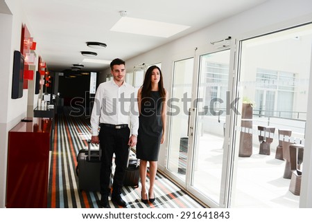 two young business person man and woman walking in a public space corridor