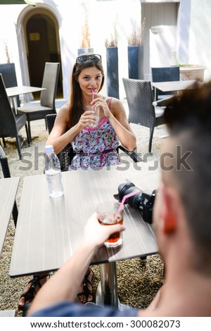 cheerful young couple having a drink in terrace outdoor