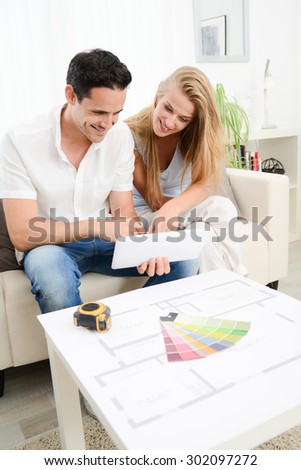 cheerful young couple making project to makeover and renovate their new house