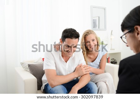 happy young couple at home in transaction signing contract with a business woman