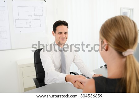 handsome young business man handshake with customer in office after signing agreement sales contract