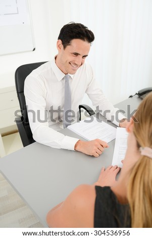 handsome young business man with customer in office signing agreement sales contract