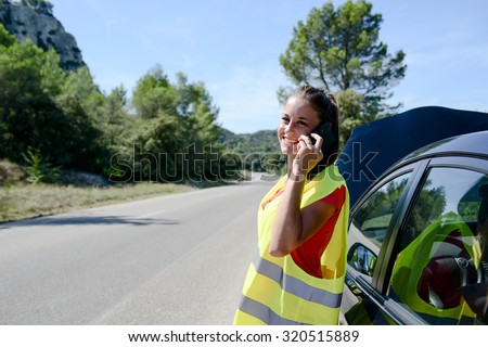 young woman with car breakdown on the roadside calling insurance company for assistance