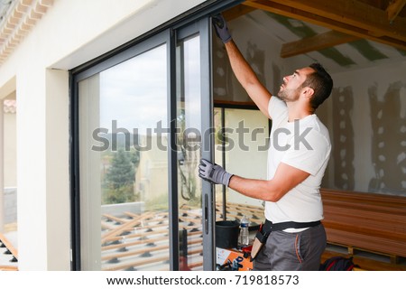 handsome young man installing bay window in a new house construction site Photo stock © 