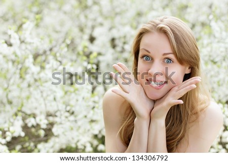 Playful young woman biting a lip and showing her hands